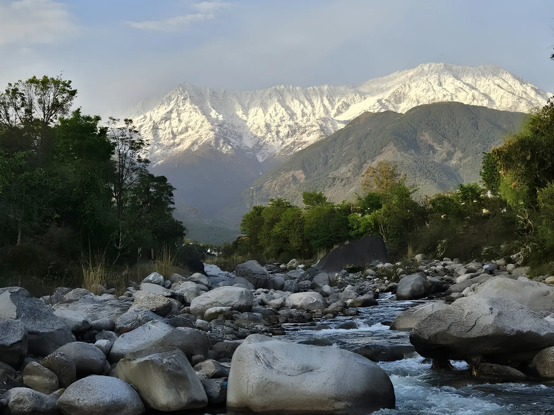 Snow-covered Dhauladhar range above a boulder-strewn mountain stream in the Kangra valley, Himachal Pradesh